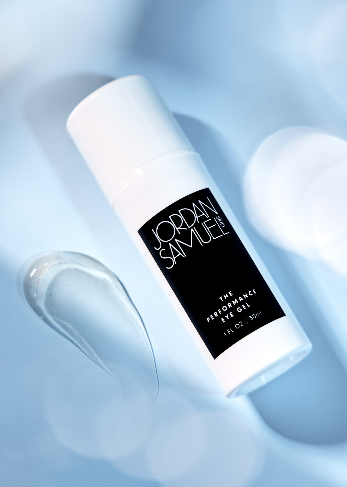 The Performance Eye Gel on a sparkling light blue background next to a swatch of the clear, luminous eye gel.